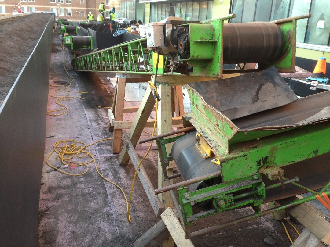 Field conveyor moving material along a tight urban site