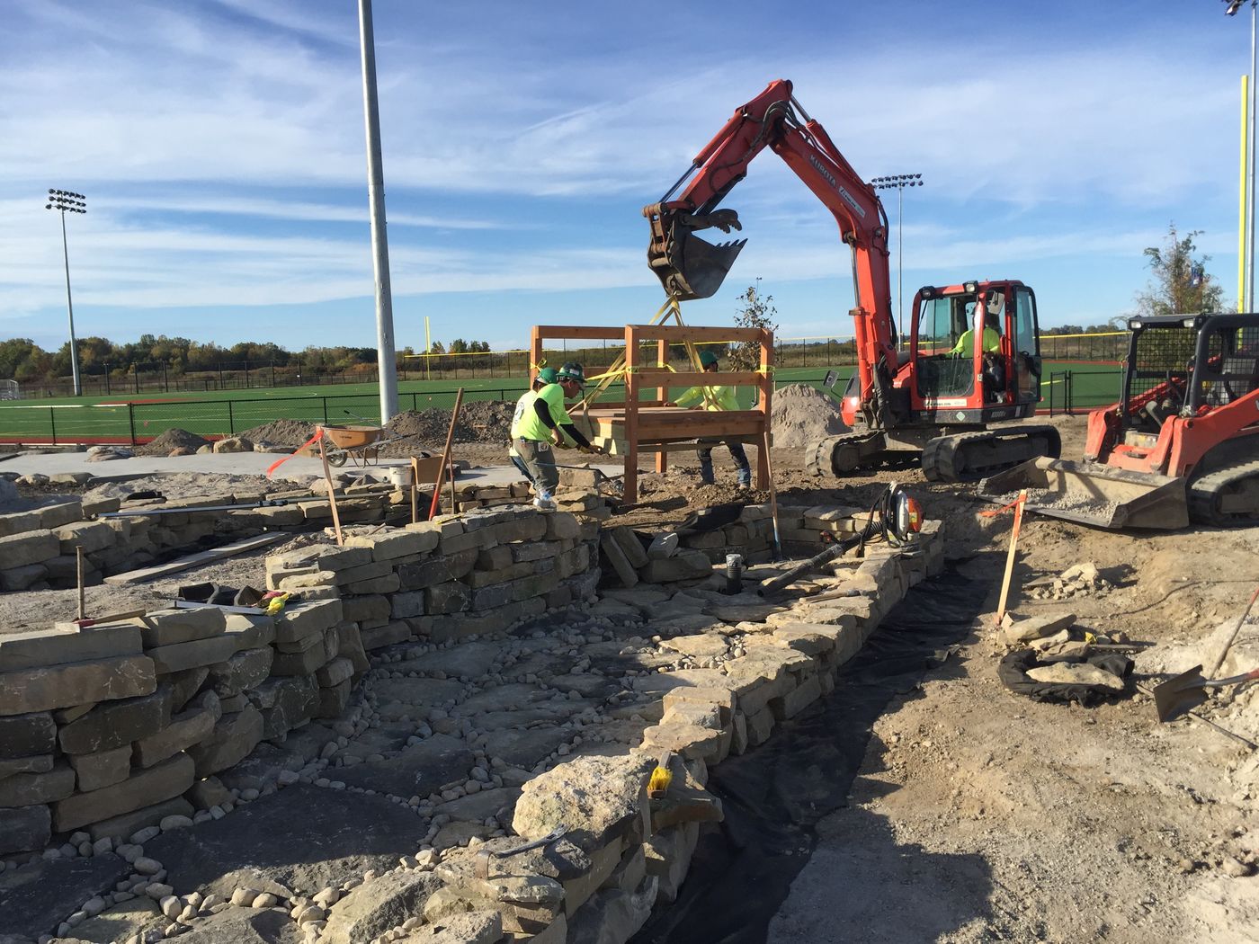 Landscape construction crew installing plantings and hardscape